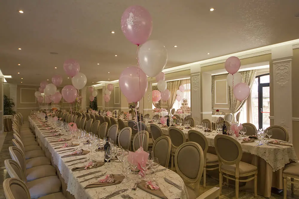 Sala da pranzo elegantemente decorata con palloncini rosa.