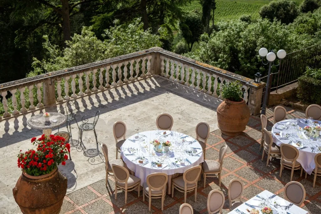Terrazza con tavoli apparecchiati per un evento elegante.