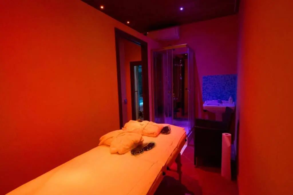 Stanza massaggi con luce soffusa e doccia.